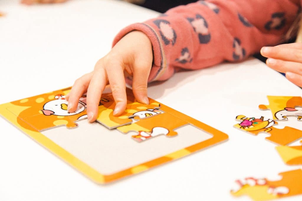 A child's development is improved by quality education. A child building a puzzle.