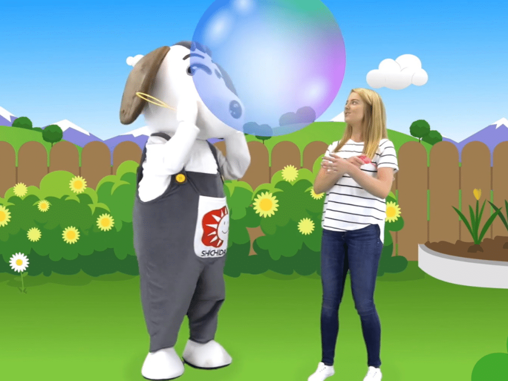 SHICHIDA at Home presenter Emma is playing with Shichi the dog, blowing a large bubble