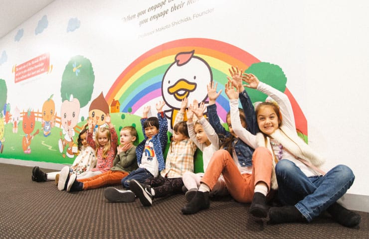 Shichida Early Learning Centre Australia, featuring 8 kids sitting in front of a colourful wall mural inside a Shichida centre