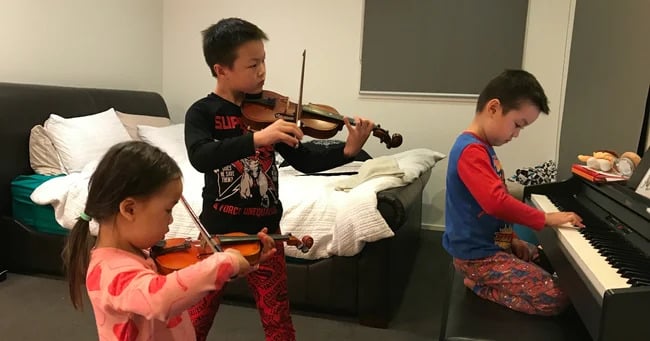 Brain training results with Shichida: Three young kids playing a variety of musical instruments.
