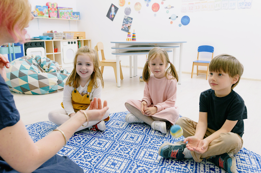 Memory games for kids: Teacher and kids sitting together on the floor, having fun and learning