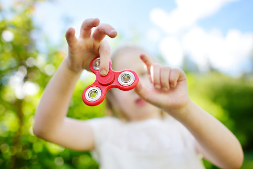 How to help an easily distracted child: a girl playing with a fidget spinner