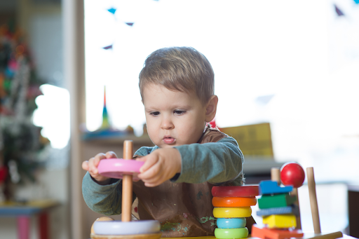 Concentration Products For Kids: Young boy playing with a shape stacker