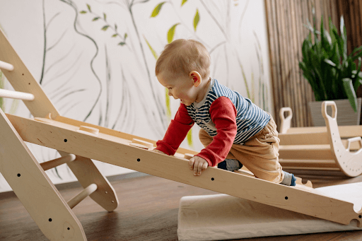 A baby climbing a low ladder