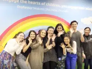 Parramatta Shichida Friendly Teachers waving in front of a rainbow mural