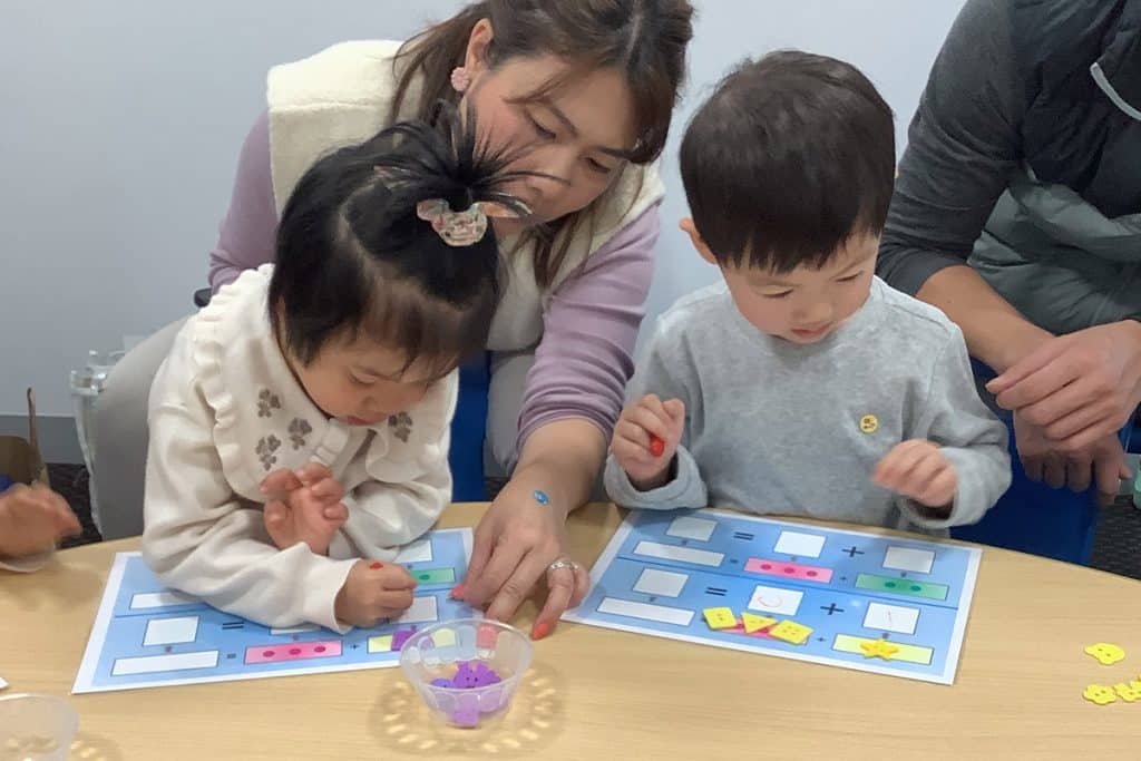 Young kids (3.5 years old) playing math addition games with their parents in a Shichida Australia class