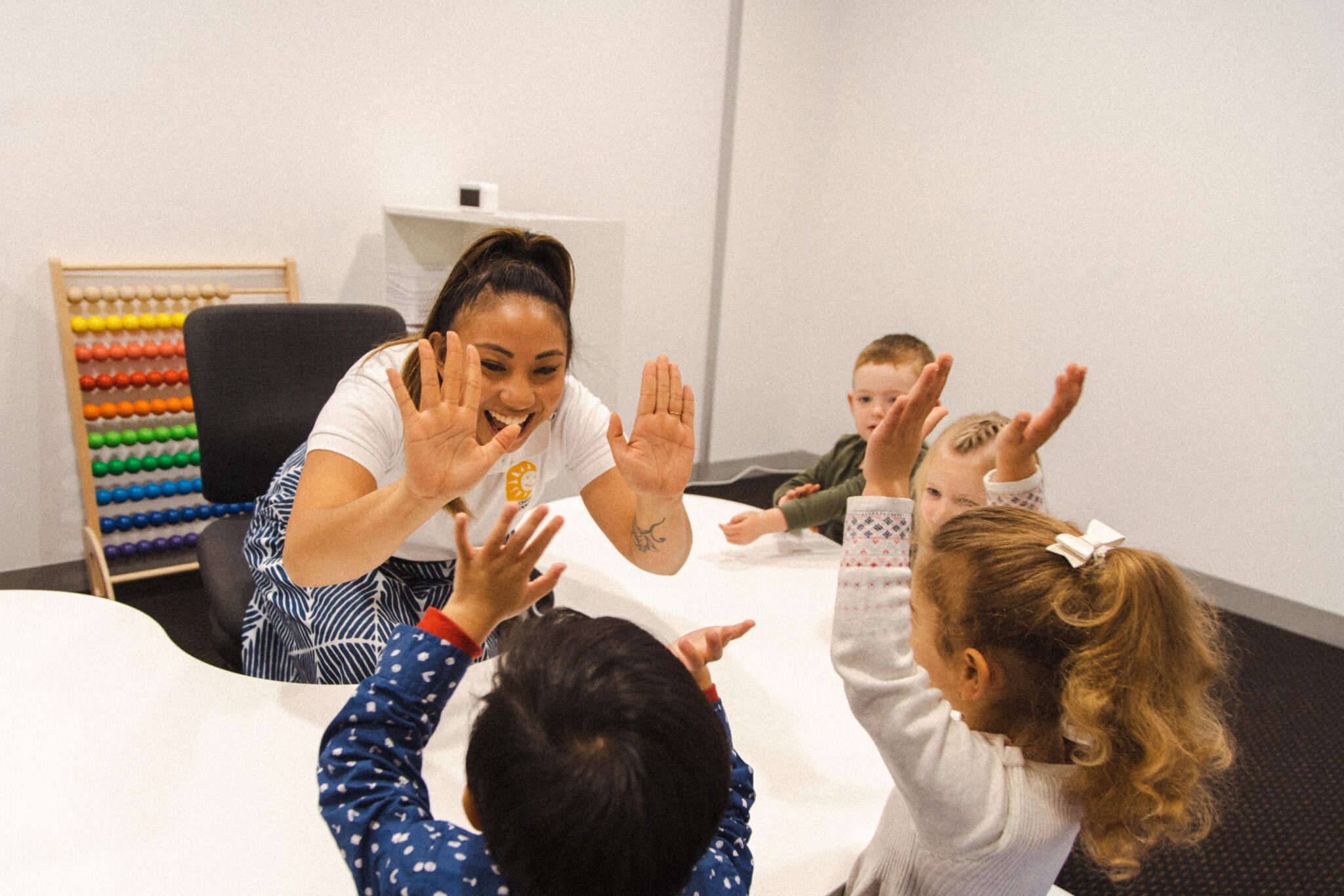 A teacher having fun in a class with four preschool kids at Shichida