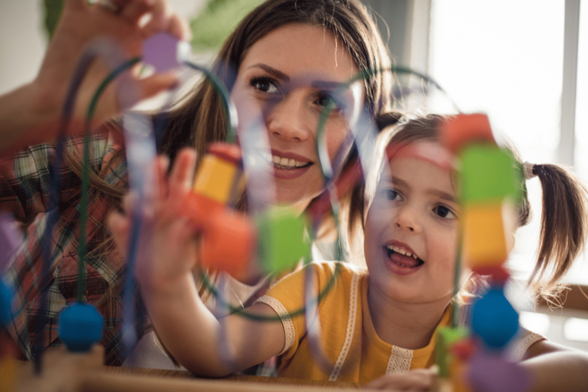 Shichida vs Montessori methods, here an adult is playing a shape game with a young girl