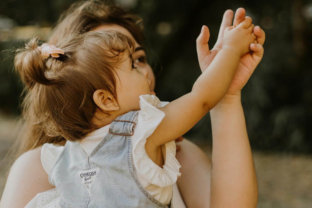 A mother holding a baby for better parenting tips to use while your child is young