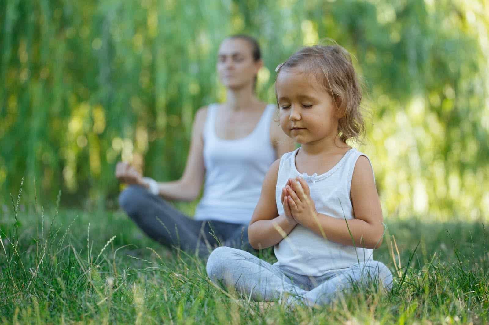 Meditation for Kids: a child and parent meditating in a garden