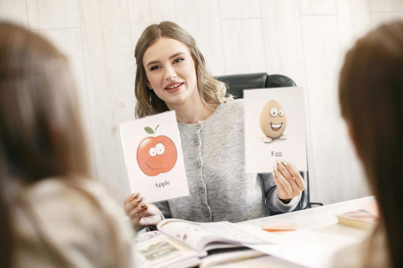 A woman holding up two Flash Cards for toddlers