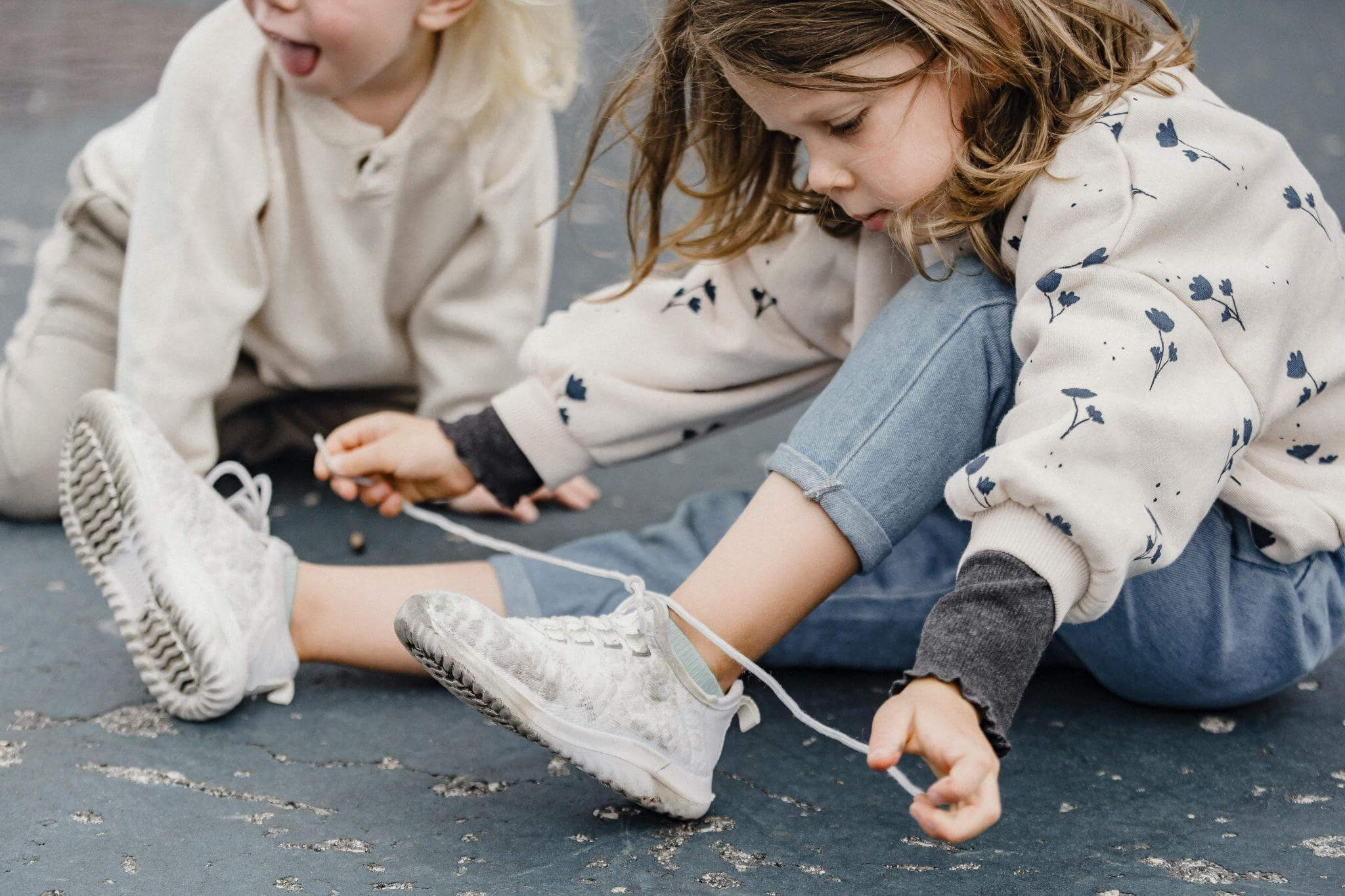 Developing fine motor skills through everyday fine motor activities, here a preschooler is tying her shoelaces.