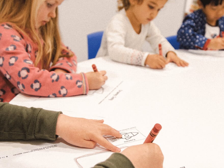 Preschoolers refining their fine motor control in a Shichida class. Here they are learning to draw a rocket using basic shapes - guided by a catchy song.
