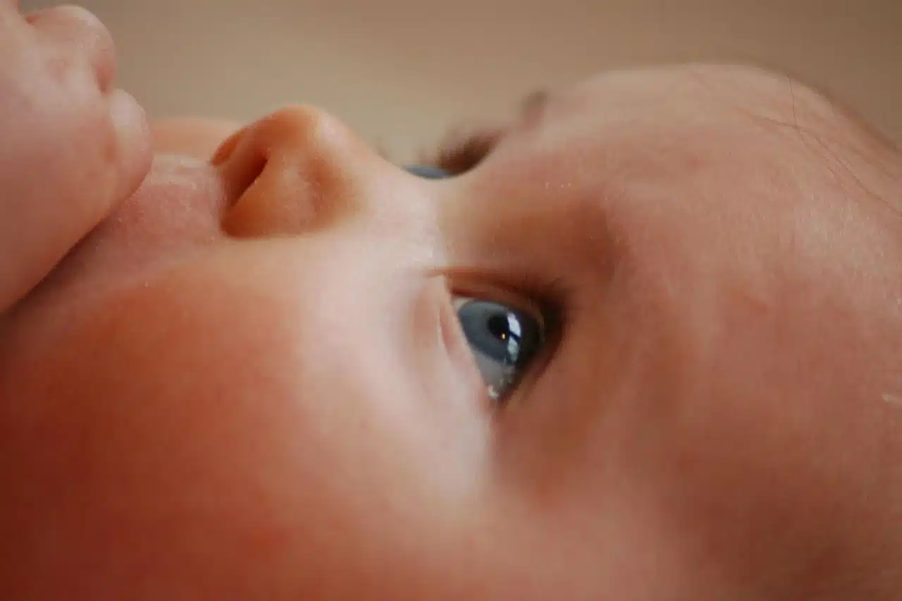 When can babies see colour? We see a babies face up close, looking upwards at something.