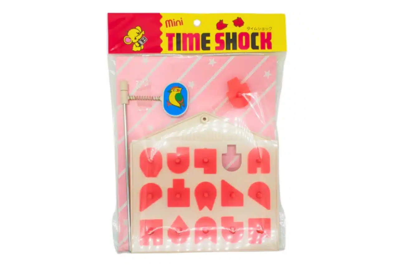 A pink and red plastic toy featuring the words "Time Shock" prominently displayed on its surface
