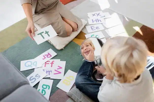 A child and an adult on the floor learning with flashcards, with the child holding a mirror.
