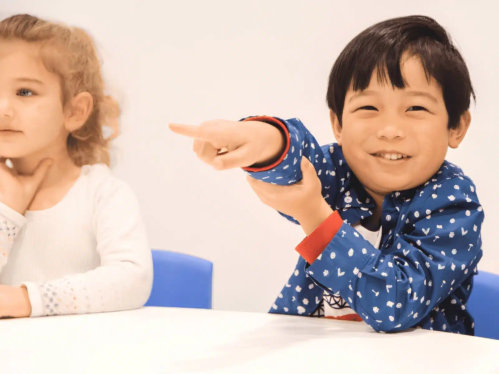 A child proudly shares his ideas in class