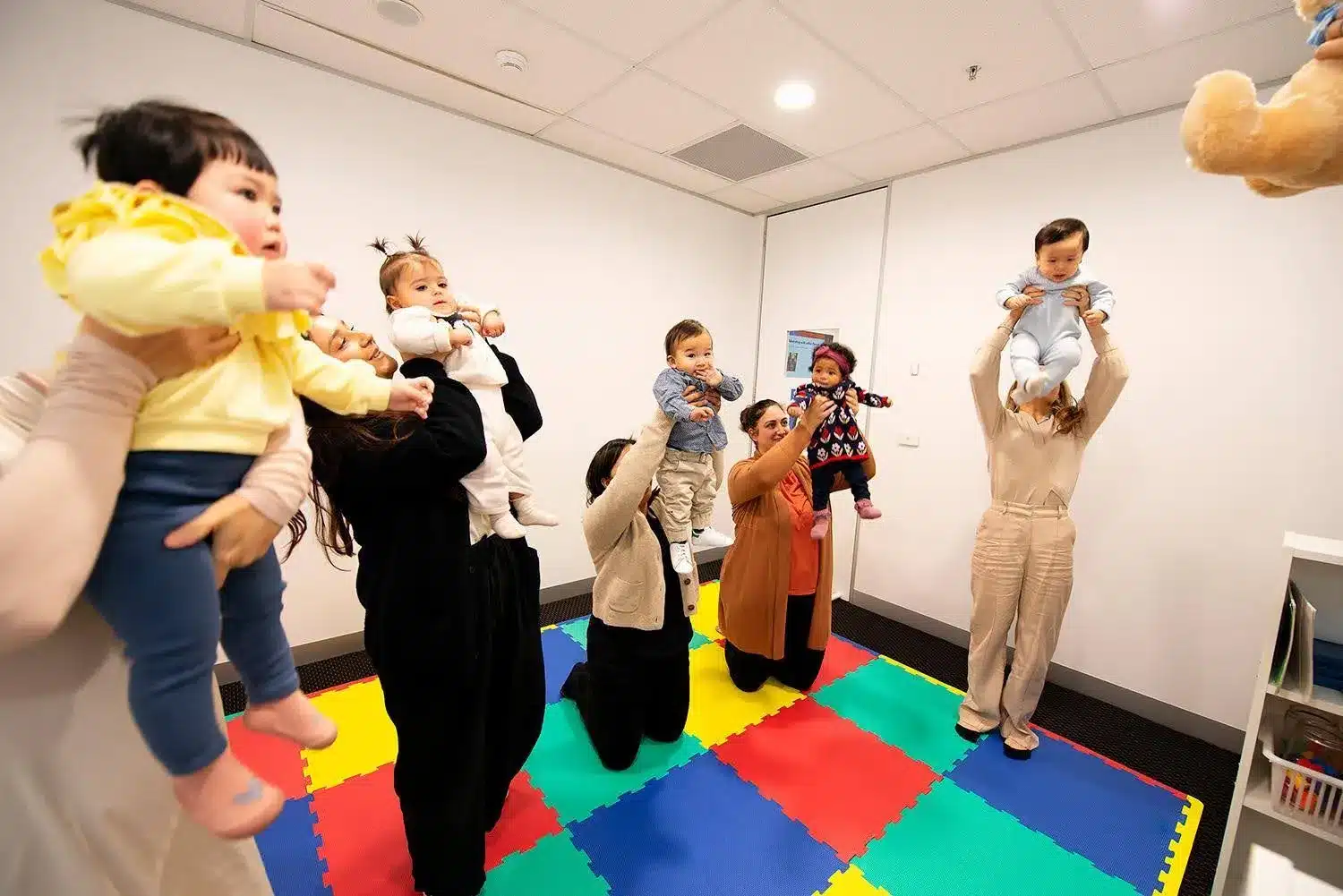 Babies and their parents move to a song in class