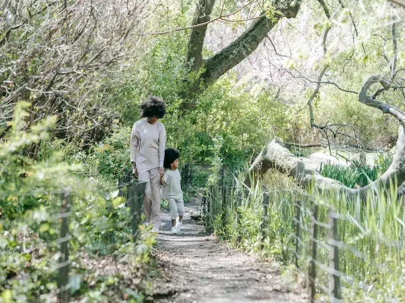 A mother and child walking through nature
