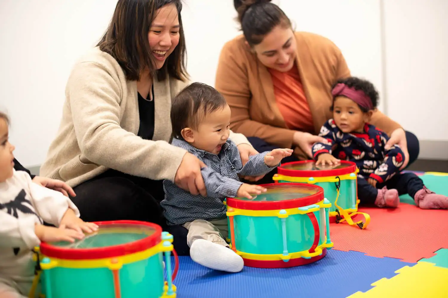 Parents and babies taking part in musical play, during a Shichida baby class.