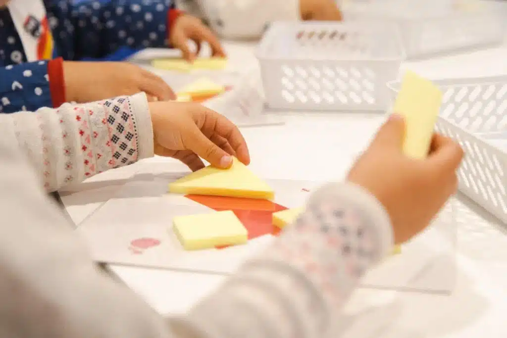 Preschooler completing a tangram shape puzzle during a Shichida class